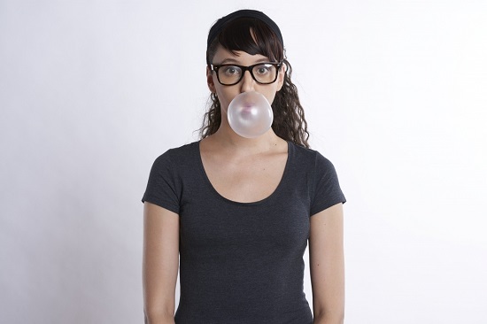 Young woman chewing a piece of dental gum