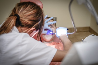Child receiving treatment from a female dentist via an amalgam filling
